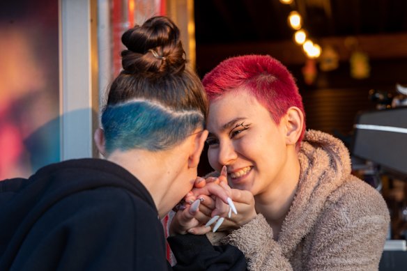 Cafe staff help each other apply make up.