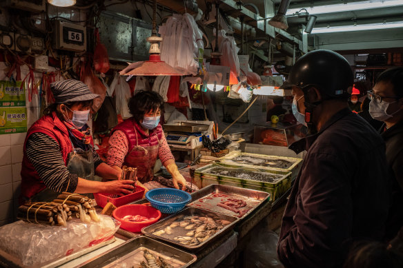 Residents wearing face mask buy seafood at a wet market in China.