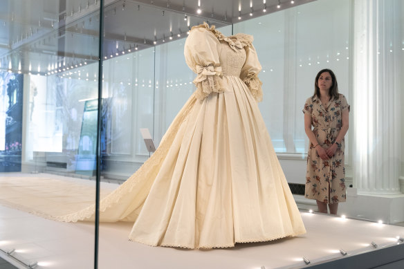 A visitor views Diana, Princess of Wales’s wedding dress displayed complete with its spectacular sequin encrusted train at the “Royal Style In The Making” exhibition at Kensington Palace.