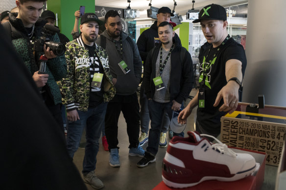 StockX executive Stephen Winn shows sneakerheads and small-business owners a custom shoe during a tour of company's offices.