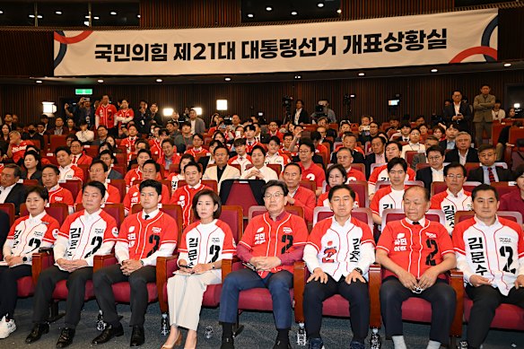 Members of the People Power Party react as they watch a television report on exit polls for South Korea’s presidential election.