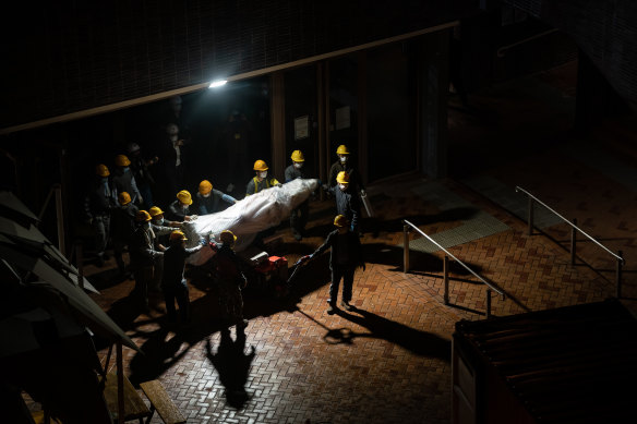 Workers remove part of the “Pillar of Shame” by Danish artist Jens Galschiot mourning the victims in Beijing’s Tiananmen Square, into a container at University of Hong Kong  in the early hours of Thursday.