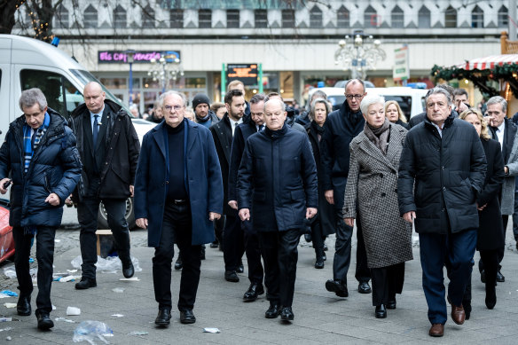 German Chancellor Olaf Scholz (centre) visits the scene of the attack.