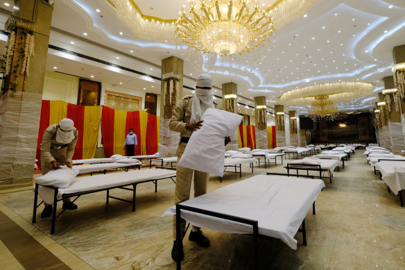 Civil defence members prepare beds in a makeshift quarantine ward in the OraBella Banquet hall in New Delhi.