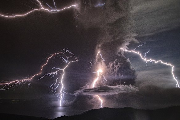 Lightning strikes as a column of ash rises from the crater of the Taal volcano.