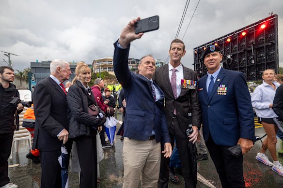 Ben Roberts-Smith is seen in the middle wearing a brown suit on Anzac Day.