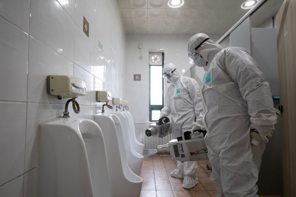 Workers disinfect the toilets at a South Korean bus depot.