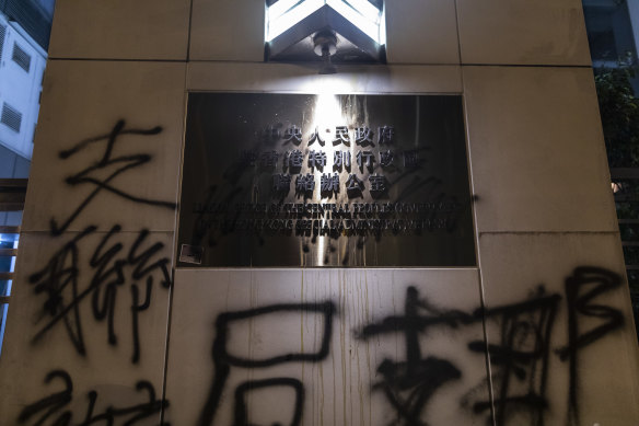Graffiti defaces a sign and a wall outside the Liaison Office of the Central People's Government during a protest in the Sai Ying Pun district of Hong Kong, China.