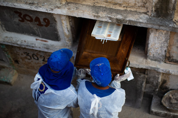 Cemetery workers bury a COVID victim  in Rio de Janeiro on Wednesday.
