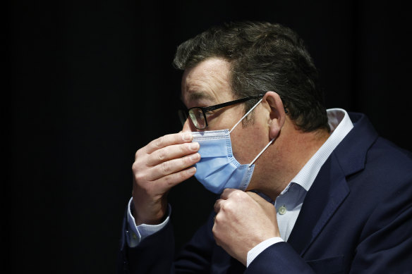 Victorian Premier Daniel Andrews adjusts his mask.