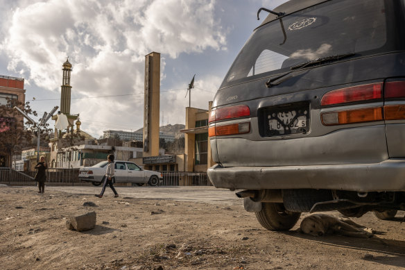A dog sleeps under a van in Kabul, Afghanistan.