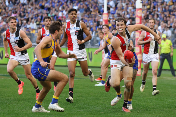 Hunter Clark of the Saints handpasses the ball under pressure from Andrew Gaff of the Eagles.