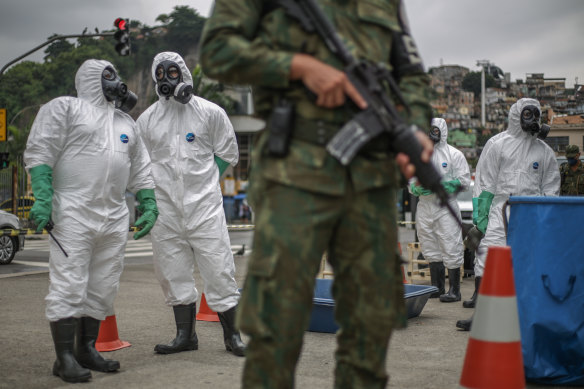 Brazil's Marine Corps soldiers from the Nuclear, Biological, Chemical and Radiological Defence division perform disinfection operations at tram stations under guard in downtown Rio de Janeiro on Thursday.