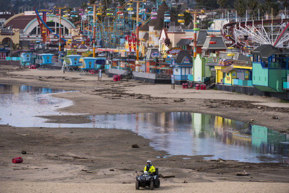 A police officer patrols main beach as waters recede in front of the Santa Cruz Beach Boardwalk.