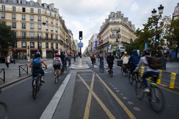 Cyclists use a bike lane on a section of Rue de Rivoli that had been converted to accommodate bike and bus traffic only. Paris is expanding its network of segregated lanes, and shifting some of them from temporary to permanent.