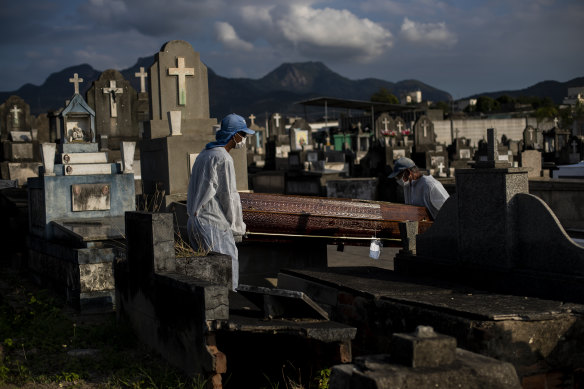 Gravediggers carry the coffin of 89-year-old Irodina Pinto Ribeiro, who died from COVID-19 related complications, at the Inhauma cemetery in Rio de Janeiro in June.