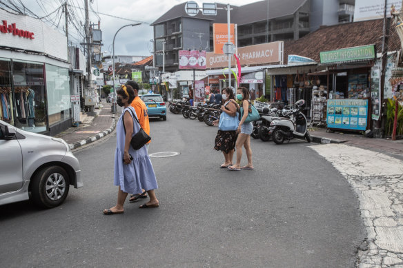 Pedestrians cross a street in Seminyak, Bali.