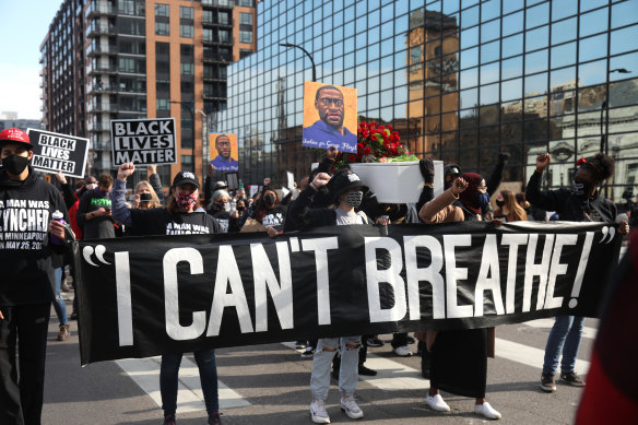 Demonstrators carry a banner during an ‘I Can’t Breathe’ Silent March For Justice in Minneapolis, Minnesota, in March 2021. Derek Chauvin knelt on George Floyd’s neck for nearly 9 minutes.