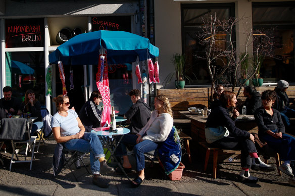 People sit outside in Berlin, Germany where the federal and state governments have relaxed COVID-related restrictions despite record high rates of infections. 