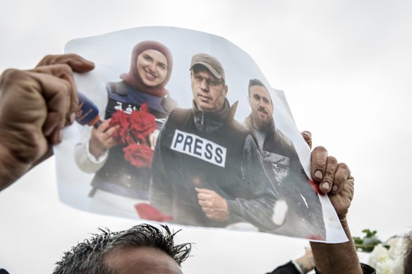 A poster is held up during a funeral ceremony in Choueifat, south of Beirut on March 29, for three journalists killed the previous day by Israeli airstrikes.
