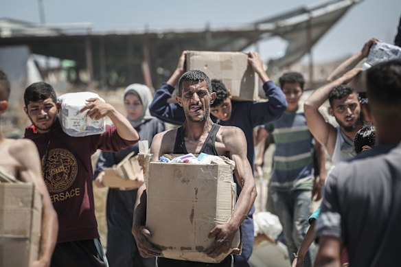 Palestinians with boxes of humanitarian aid from a distribution centre in the Netzarim Corridor, central Gaza Strip, on Thursday.