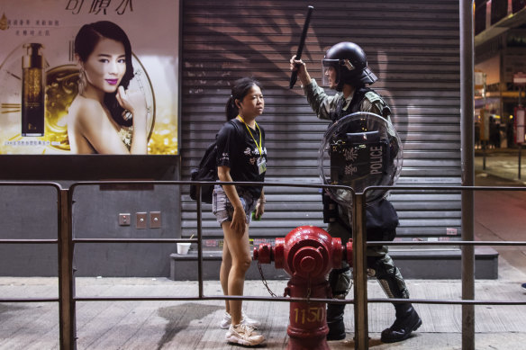 A riot police stands off against a woman during a protest in the Mong Kok district of Hong Kong, China, on Saturday night. 