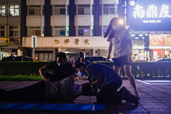 Sue Chang (right) and her civil defence group practise first aid skills on the footpath in Taoyuan, Taiwan.