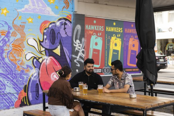 People enjoy a drink at a bar on High Street, Thornbury.