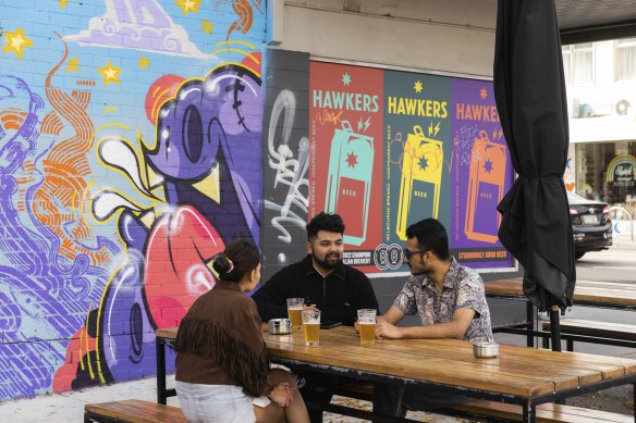 People enjoy a drink at a bar on High Street, Thornbury.