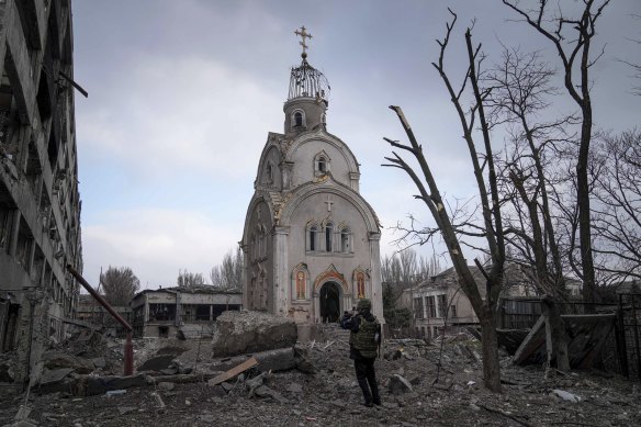 A Ukrainian serviceman stops to take a photo of a the ruins of a church in Mariupol. 