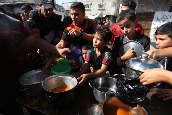 Palestinians queue to receive food at a makeshift charity kitchen in the southern Gaza Strip city of Rafah on Saturday.