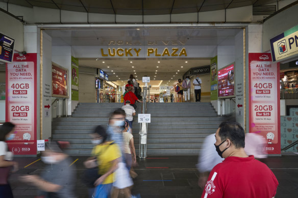 Customers wait in line to enter the Lucky Plaza on Orchard Road in Singapore due to coronavirus restrictions.
