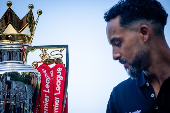 Former Arsenal player Theo Walcott with the Premier League trophy.