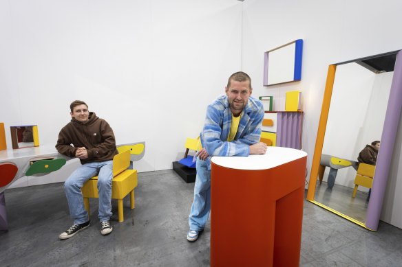 Mark and Jack Fearon, tradies turned designers, at the Melbourne Design Fair with their brightly coloured furniture designs.