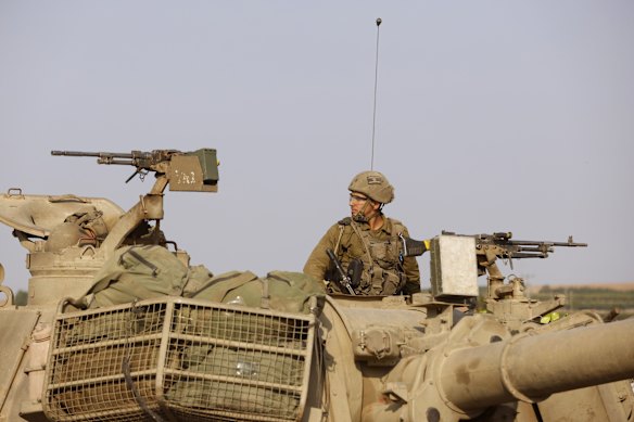 Israeli security forces aboard an infantry fighting vehicle move towards the border with Gaza.