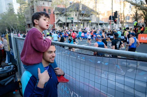 Nicolas Soares and his son watch on in North Sydney.