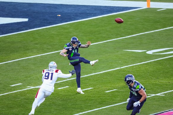 Michael Dickson punts the ball.