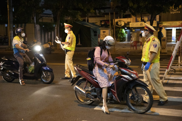 Motorcyclists are stopped at a security checkpoint earlier this month during a stay-at-home order in Vietnam’s Ho Chi Minh City.