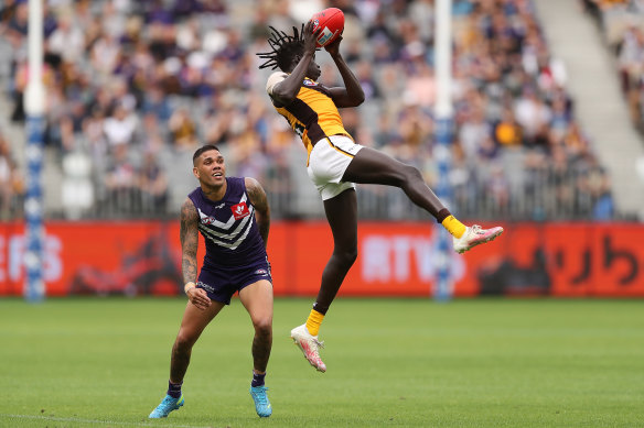 Hawthorn’s Changkuoth Jiath takes an athletic overhead mark in front of Fremantle star Michael Walters.