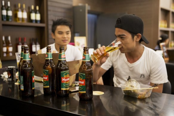 Customers drink Myanmar Beer, manufactured by Myanmar Brewery Ltd, at a bar in Yangon, Myanmar, before the coup.