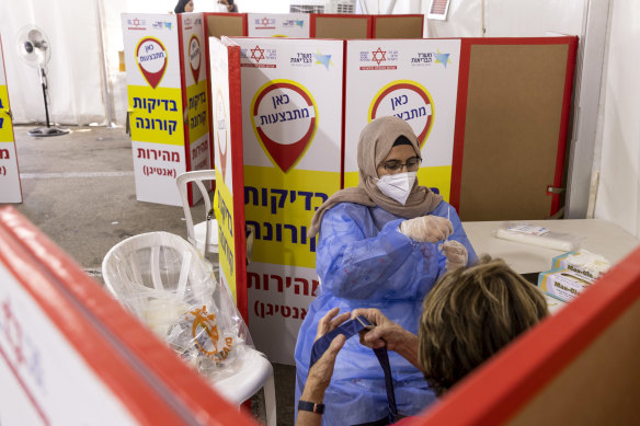 A health worker prepares a swab for rapid antigen testing at a drive-through  facility in Tel Aviv in Israel.