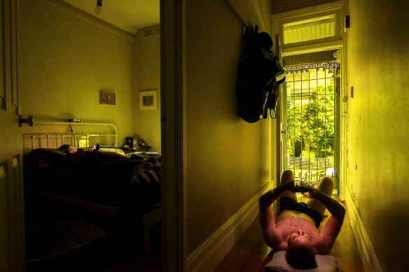 A man tries to cool down during a heatwave in Sydney, 2019, by lying on the floorboards. 