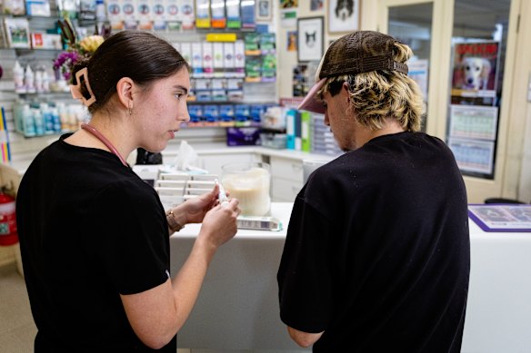 Emily Pratten explains medications to Jake before discharging his dog, Elbie, from the vet. 