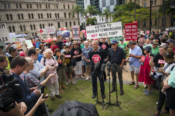 Brown, flanked by businessman Geoffrey Cousins, addresses a rally in Brisbane to protest against the proposed Adani Carmichael coalmine.