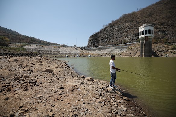 A Miguel Alemán dam worker fishes during his free time on one of the rocks that was exposed after the dam dried to 31.4 percent of its total capacity on February 28, 2024 in Valle de Bravo, Mexico.