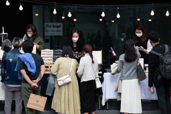 COVID-19 style: people wearing protective masks look at accessories in the Gangnam district of Seoul.