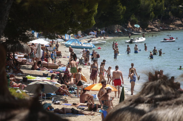 Sunbathers enjoy the beach in Pollença, in the Balearic Island of Mallorca.