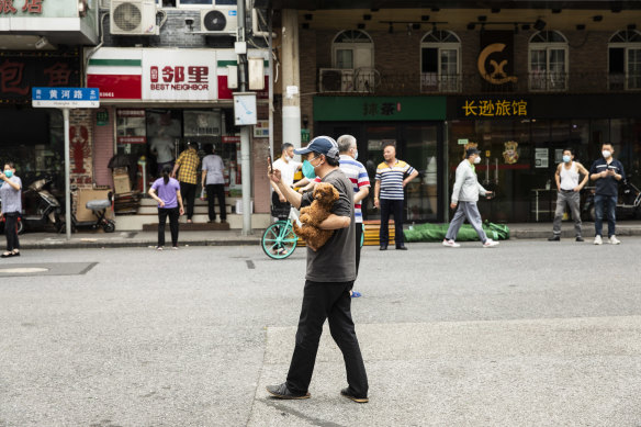 Shanghai resident takes his dog for a walk during the allocated time outside on the last day of the lockdown. 