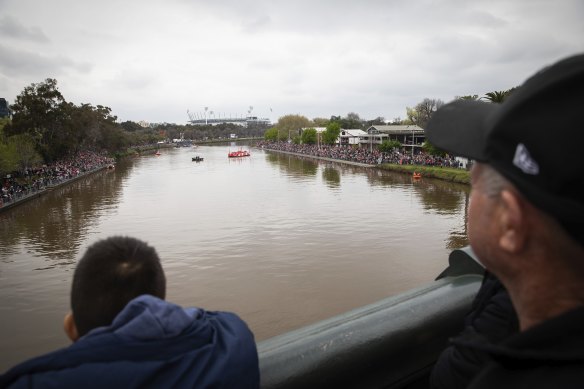 Crowds flocked to the banks of the Yarra River to see the AFL grand final players on boats - but they needed binoculars to get a proper glimpse.