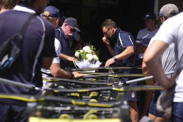 School staff members place a bouquet of white flowers on Edward’s seat.